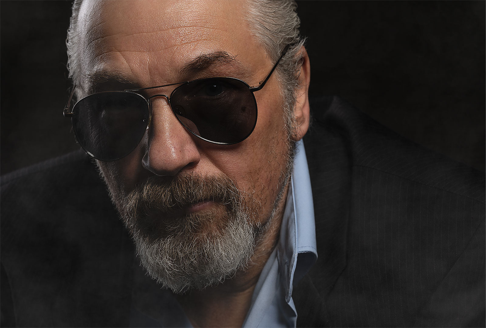 Ausdrucksstarkes Cinematic Portrait eines Mannes mit Sonnenbrille und ernstem Blick – fotografiert im Stil von Film-Stills und modernen Kampagnen-Visuals.